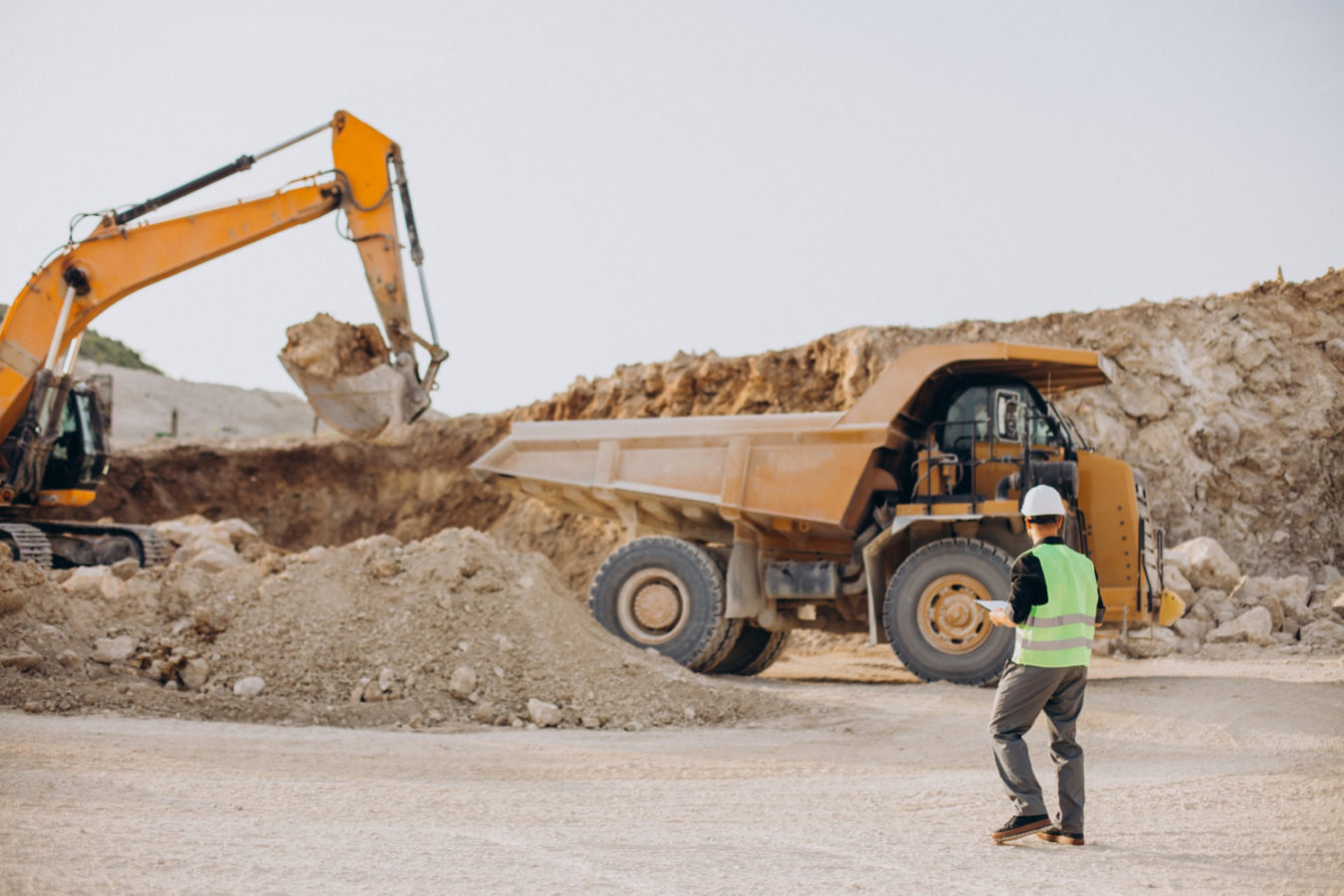 imagem mostra engenheiro em uma mina orientando o caminhão, ilustra um artigo sobre engenharia de minas