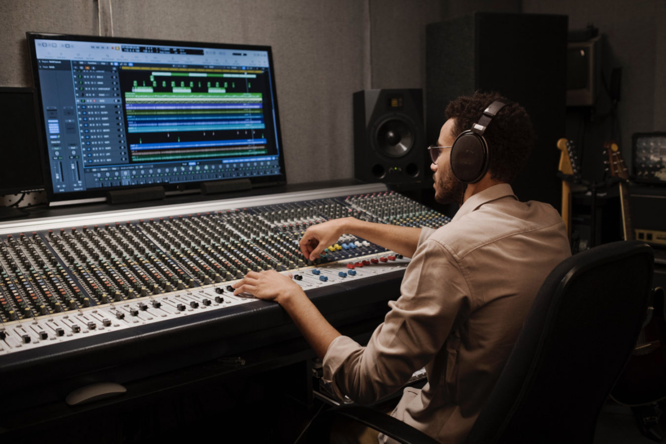 imagem mostra homem em estúdio usando equipamentos acústico, aprendizagem de engenharia acústica